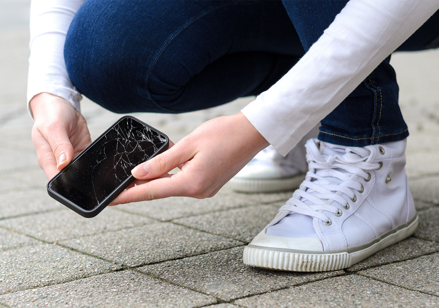 Woman Picking Up Damaged iPhone from Street