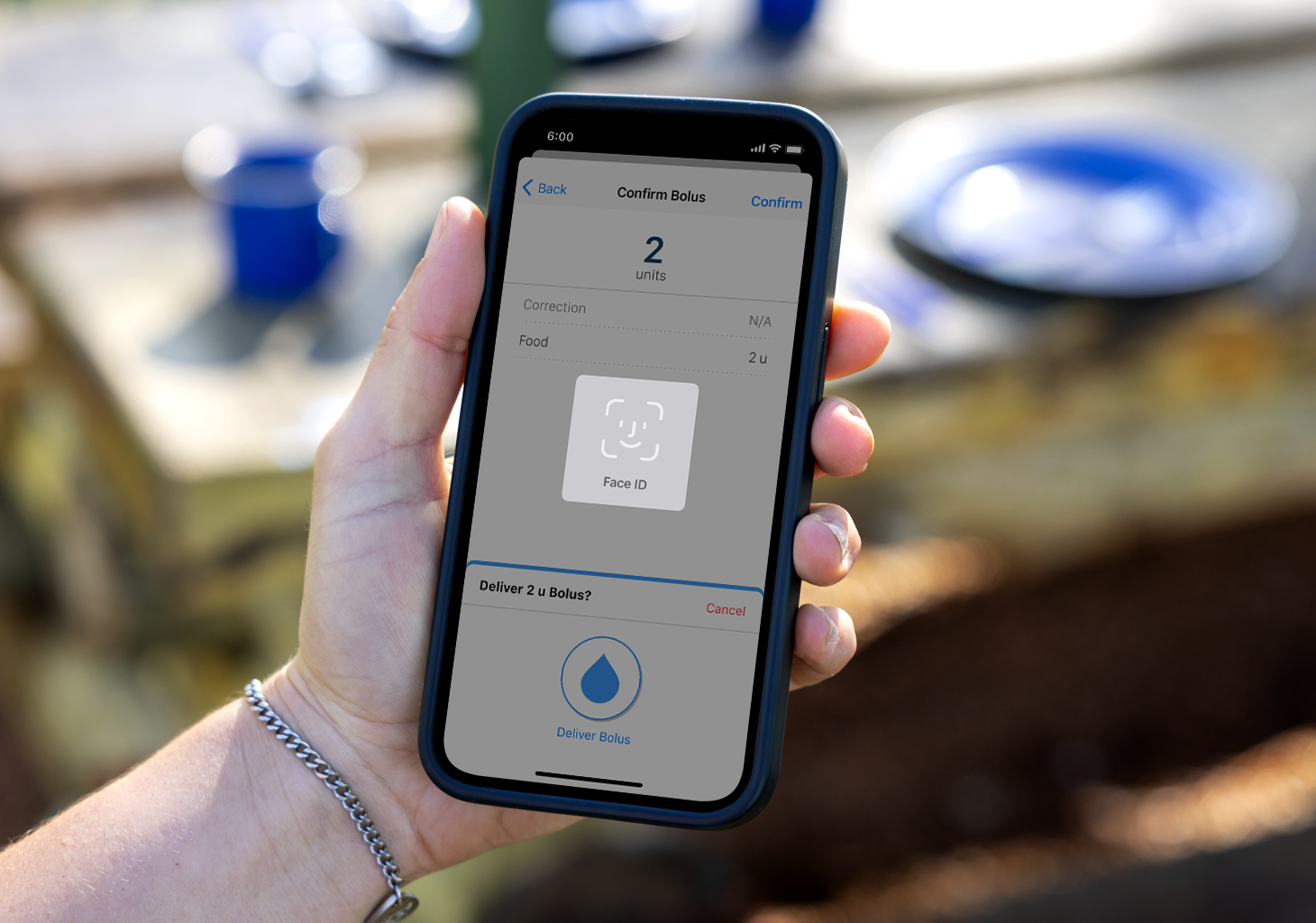 Woman holding phone showing the Bolus screen with Face ID prompt