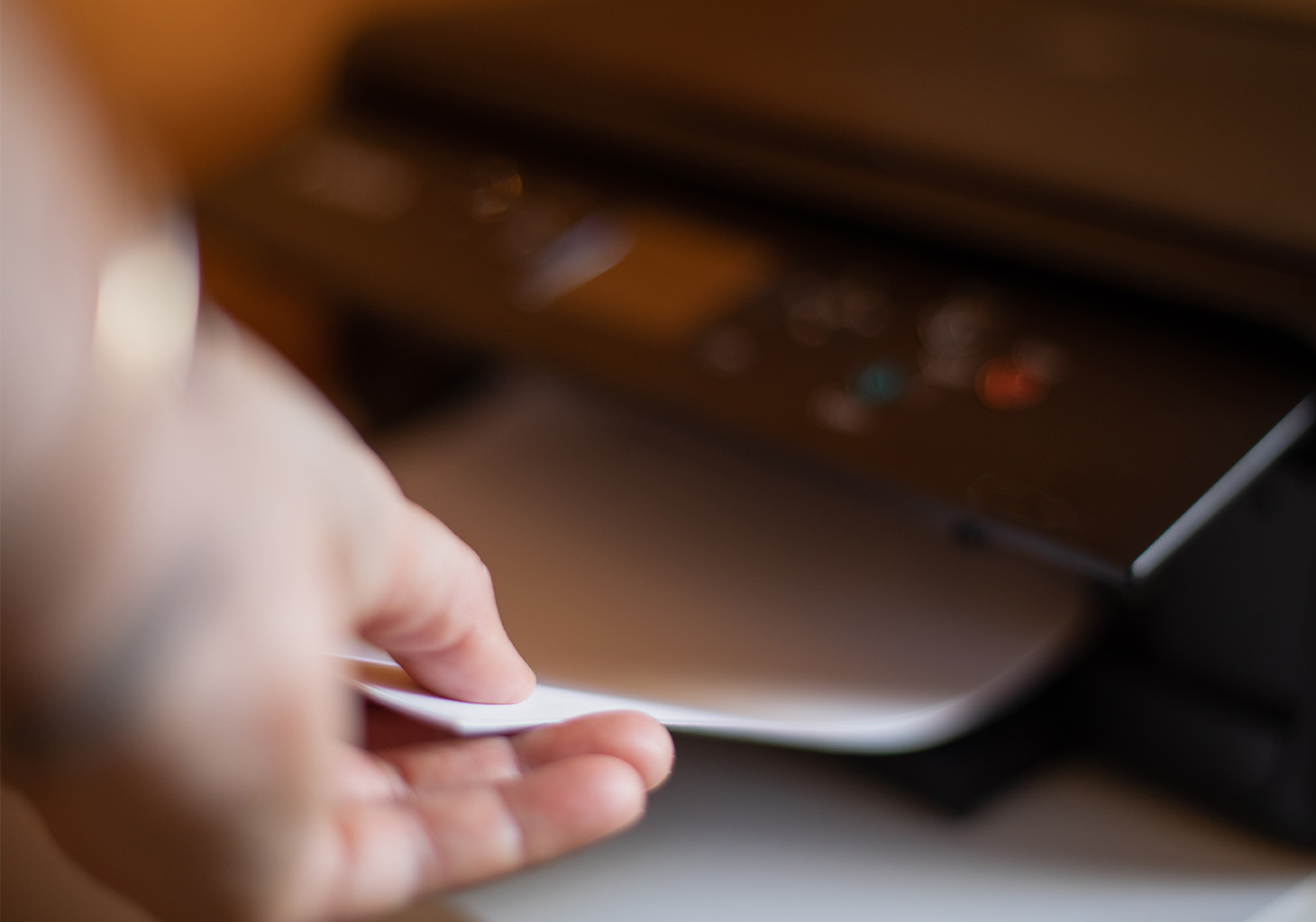 Man Pulling Paper from Printer