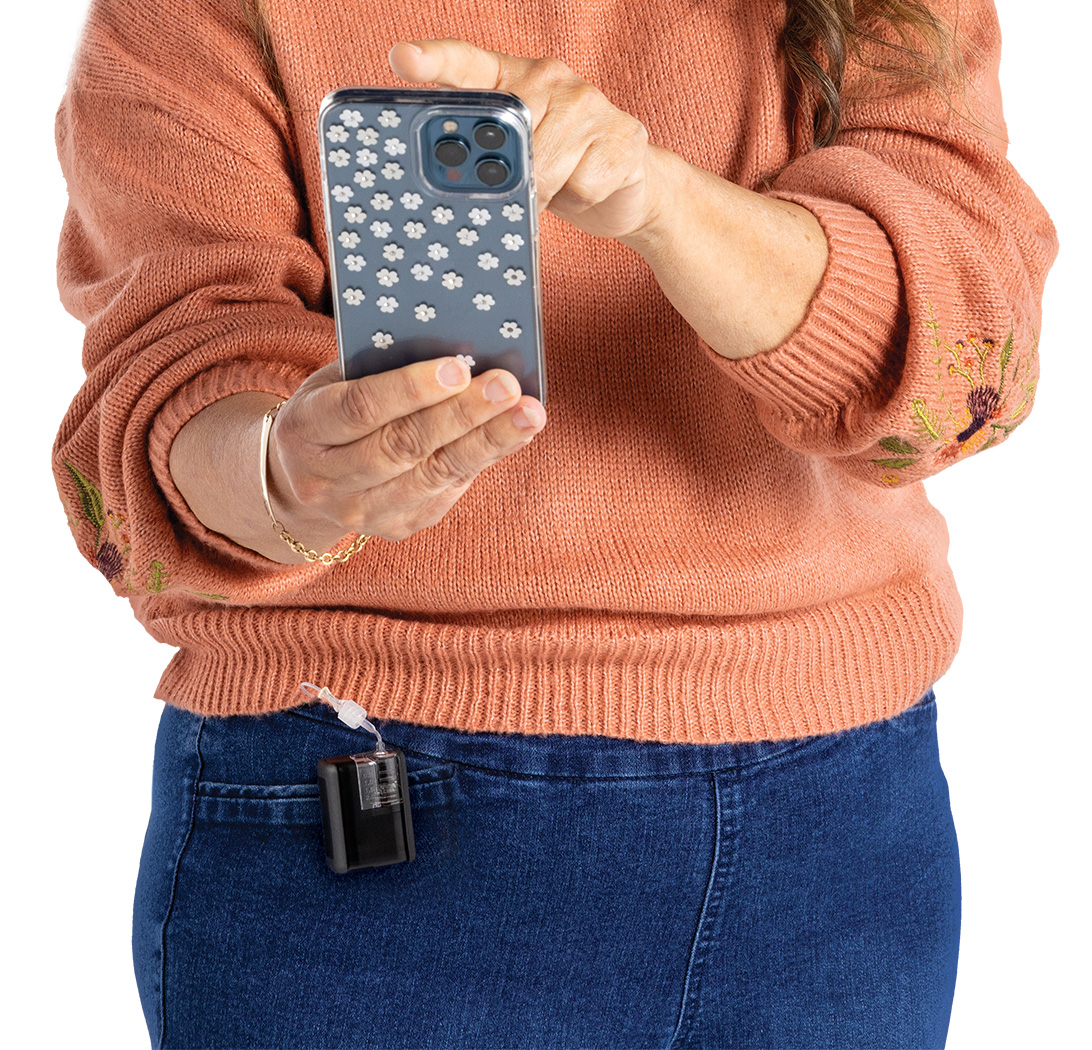 Pump user with a Tandem Mobi clipped to their pant pocket shown using the mobile app on their smartphone