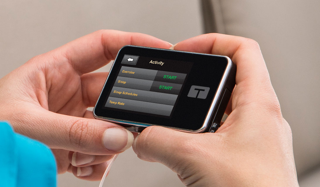 Hands holding the Tandem t:slim X2 Insulin Pump showing the Activity screen