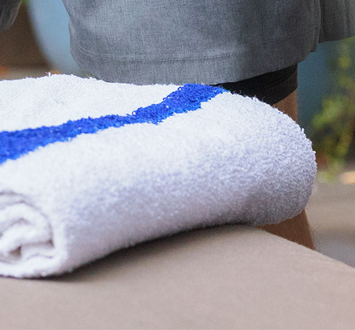 A folded white towel with a blue stripe